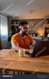 stock photo young african american man sitting at home using laptop for video call 2416560573